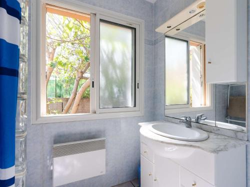 une salle de bain avec un lavabo et deux fenêtres dans l'établissement Maison de vacances à 300m de la plage avec 3 chambres, parking privé et jardin équipé - FR-1-409-267, à Fleury