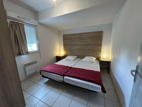 a bedroom with a large bed with a red blanket at Appartement Le Grau-du-Roi, 3 pièces, 6 personnes - FR-1-250-268 in Saint-André-Lachamp