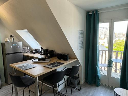 une cuisine avec une table avec des chaises et un réfrigérateur dans l'établissement Appartement 3 pers refait à neuf près plage/thalasso à Cabourg, balcon, cuisine équipée - FR-1-487-366, à Cabourg