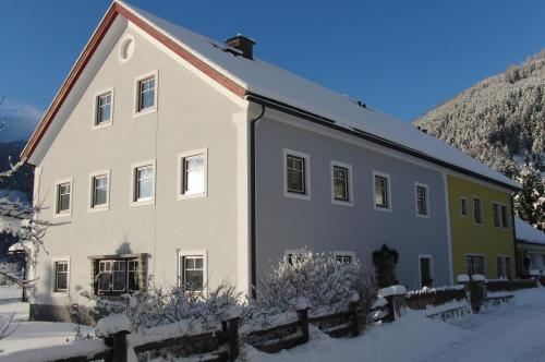 a large white building with snow on the ground at Apartment Aineckblick in Sankt Michael im Lungau