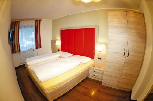 una camera con un grande letto e un armadio rosso di Amazing apartment house Diamant with breathtaking view a Santa Cristina in Val Gardena