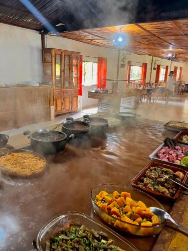 a kitchen with many dishes of food on a table at Hotel Fazenda Rancho Mineiro in Engenheiro Paulo de Frontin