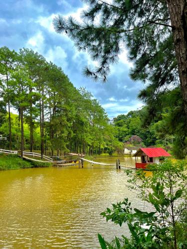 a river with a house in the middle at Hotel Fazenda Rancho Mineiro in Engenheiro Paulo de Frontin
