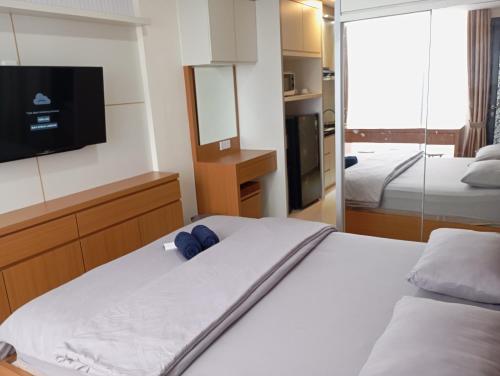 1 dormitorio con 1 cama y TV en la pared en SleepRest @ Pollux Habibie en Batam Center