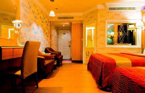 a hotel room with two beds and a desk at Wen Sha Bao Motel-Xinying in Xinying