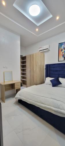una camera con un grande letto e una scrivania di Blue Luxury a Awoyaya
