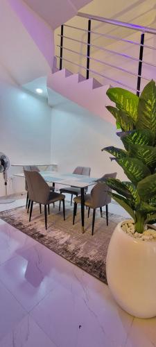 une salle à manger avec une table et une plante en pot dans l'établissement Blue Luxury, à Awoyaya