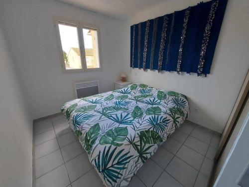 een slaapkamer met een bed met een bloemenbed bij Maison Le Grau d'Agde, 3 pièces, 6 personnes - FR-1-423-302 in Le Grau-dʼAgde