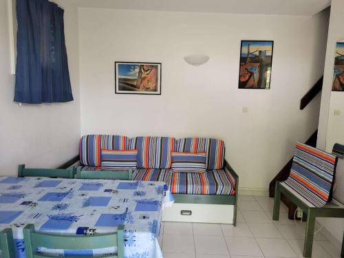 a room with a couch and a table and chairs at Maison Vendres, 3 pièces, 4 personnes - FR-1-701-82 in Vendres