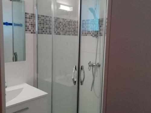 a bathroom with a glass shower with a sink at Maison Vendres, 3 pièces, 4 personnes - FR-1-701-82 in Vendres