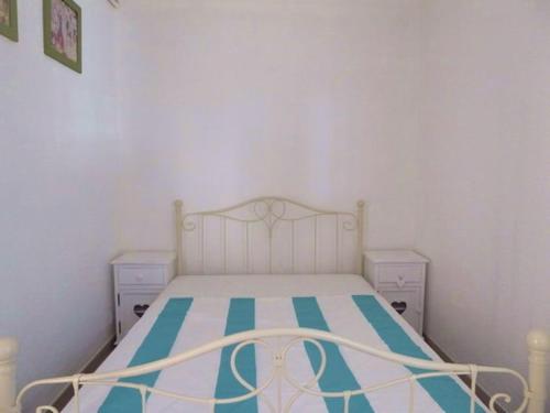 une petite chambre avec un lit et deux tables de nuit dans l'établissement Appartement rénové à 50m de la plage avec jardin et WIFI - FR-1-776-94, à Argelès-sur-Mer