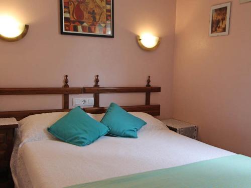 um quarto com uma cama com duas almofadas azuis em Villa Moraira, 3 pièces, 4 personnes - HISP-216-216 em Teulada