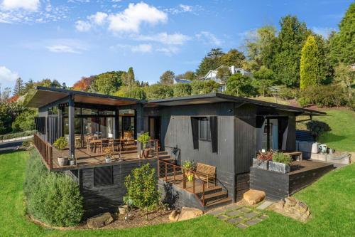 a small house with a deck and a patio at Sanctuaire, Southern Highlands in Mittagong