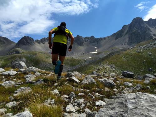a man with a backpack running on a mountain at Zagori Suites Luxury Residences in Vitsa