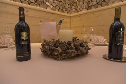 two bottles of wine and a candle on a table at Sport Hotel Prodongo in Brallo di Pregola