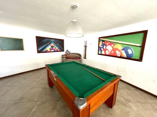 a room with a pool table and paintings on the wall at Apartamento até 8 Pessoas Praia Grande - Le Bon Vivant in Arraial do Cabo