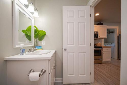 a white bathroom with a sink and a mirror at Seaside Retreat in Rockport