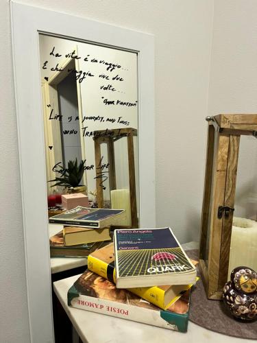 a mirror with a laptop and books on a table at A Casa Nostra in Rome