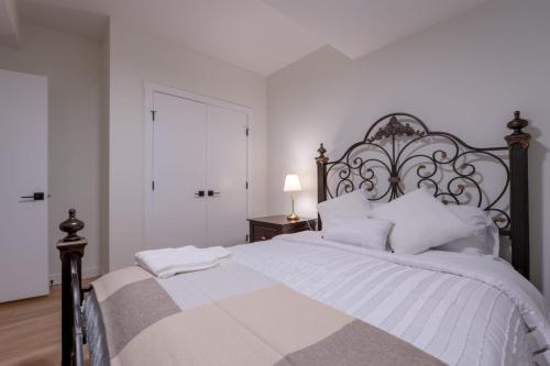 a white bedroom with a large bed with white pillows at Peaceful basement, Calgary city in Calgary