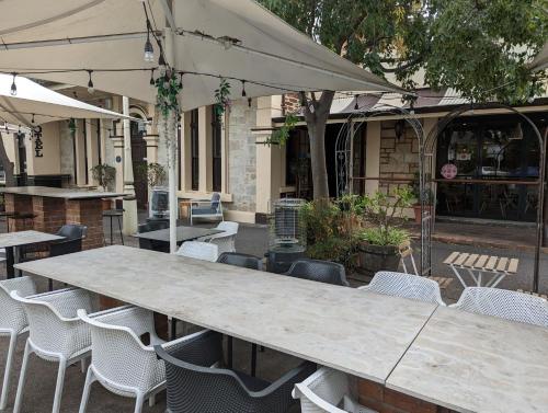 a large table with chairs and an umbrella at Rob Roy Room 1 in Adelaide