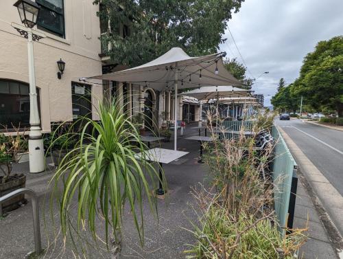 a table with an umbrella on the side of a street at Rob Roy Room 1 in Adelaide