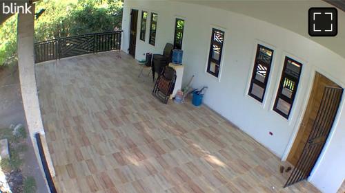 an empty room with a wooden floor and a balcony at MaNelly Guest House Hotel in Donsol