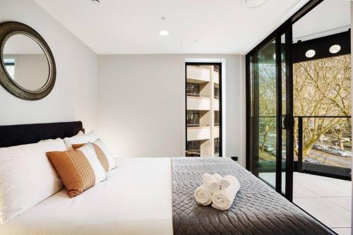 a bedroom with a bed with two white towels at Modern 1-Bedroom City Centre in Auckland