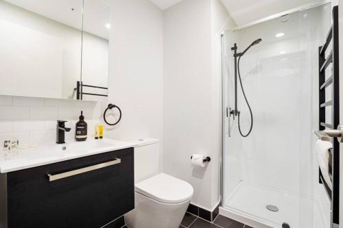 a white bathroom with a toilet and a shower at Modern 1-Bedroom City Centre in Auckland