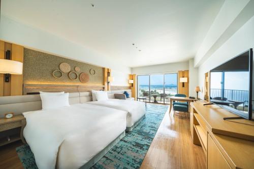 本部的住宿－オリオンホテルモトブリゾート&スパ，酒店客房设有一张大床和一台电视。