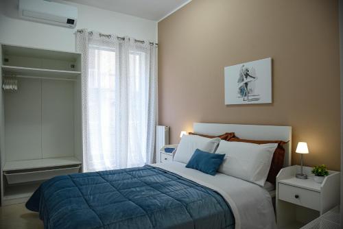 ein Schlafzimmer mit einem Bett mit einer blauen Decke und einem Fenster in der Unterkunft Kalsa Casa dei Mori in Palermo