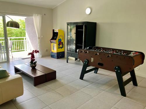 a living room with a pool table and a game room at chez Gérald in Noumea