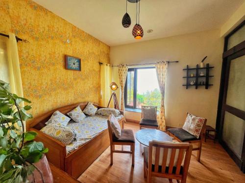 a bedroom with a bed and a table and chairs at Mysa by Meraki - Entire Villa with Himalayan Views in Rānīkhet