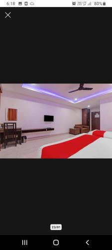 een slaapkamer met een rood en wit bed en een televisie bij Hotel SS PALACE in Lucknow