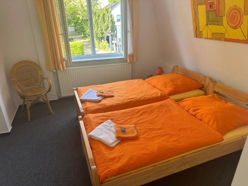 a bedroom with two beds with towels and a window at Die kleine Pension in Delmenhorst