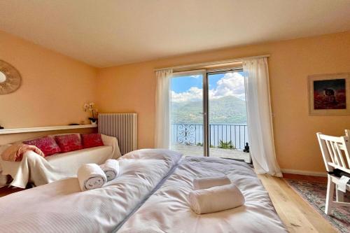 a bedroom with two beds and a large window at Peace Over The Lake Rooms - Happy Rentals in Brissago