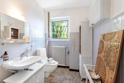 a white bathroom with a sink and a toilet at Peace Over The Lake Rooms - Happy Rentals in Brissago