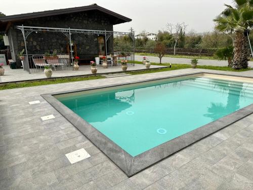 a swimming pool in front of a house at Casa vacanze con piscina riscaldata - Uso Esclusivo in San Giovanni la Punta