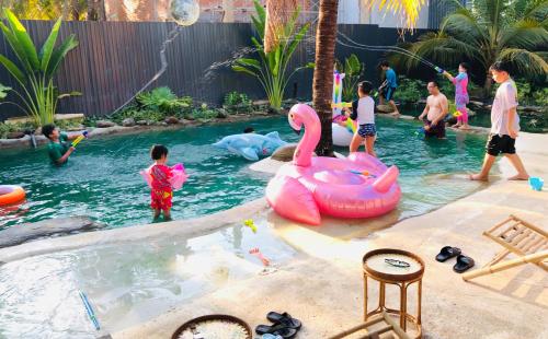 Cóc Retreat Mỹ Tho City في مي ثو: مجموعة اطفال يلعبون في المسبح