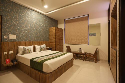 a bedroom with a bed and a table and a window at Hotel Golden Tower At Delhi Airport in New Delhi