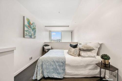 a white bedroom with a bed and a window at Loft Apartment in Wellington