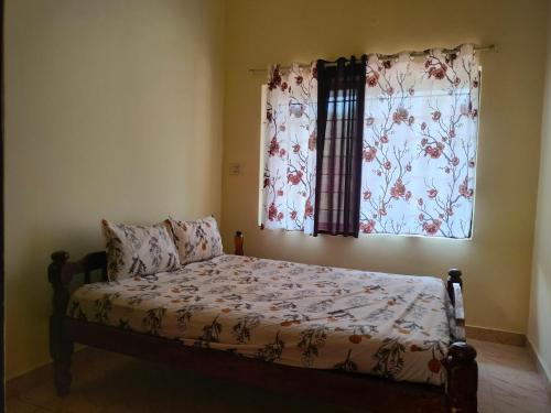 sypialnia z łóżkiem i oknem z zasłonami w obiekcie White bungalow w mieście Madikeri