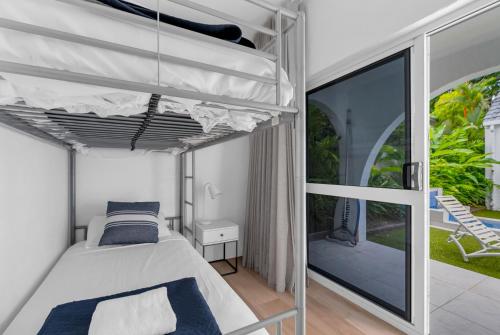 a bedroom with a bed and a balcony at Ohana Palm Cove in Palm Cove
