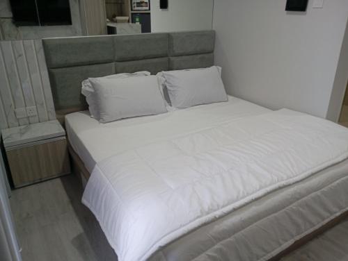 a large bed with white sheets and pillows at SleepRest - Nuvasa Bay in Nongsa
