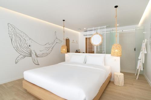a bedroom with a white bed with a whale graphic on the wall at The Season Rayong in Ban Chamrung