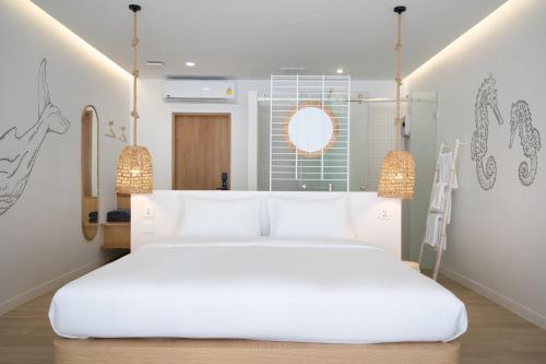 a bedroom with a large white bed and a mirror at The Season Rayong in Ban Chamrung