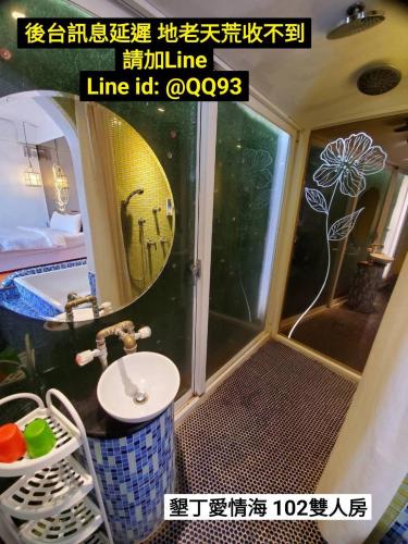 a bathroom with a shower with a sink and a toilet at 墾丁愛情海民宿 in Kenting