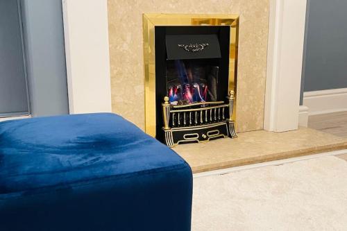 a living room with a fireplace with a blue mattress at King-size bed en- suit, Luxury refurbished home in Balderton