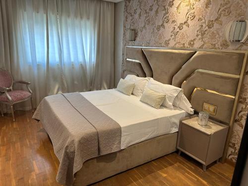 - une chambre avec un grand lit et une chaise dans l'établissement Appartement à Casablanca de luxe, à Casablanca