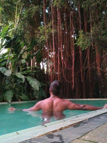 a man in a swimming pool next to a tree at Islandwide G camping in Kurunegala