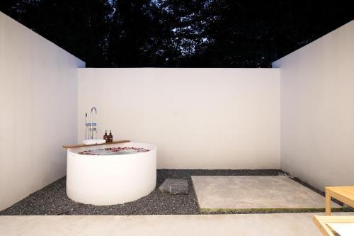 a white bathroom with a tub in a white wall at The Season Resort in Ban Chamrung